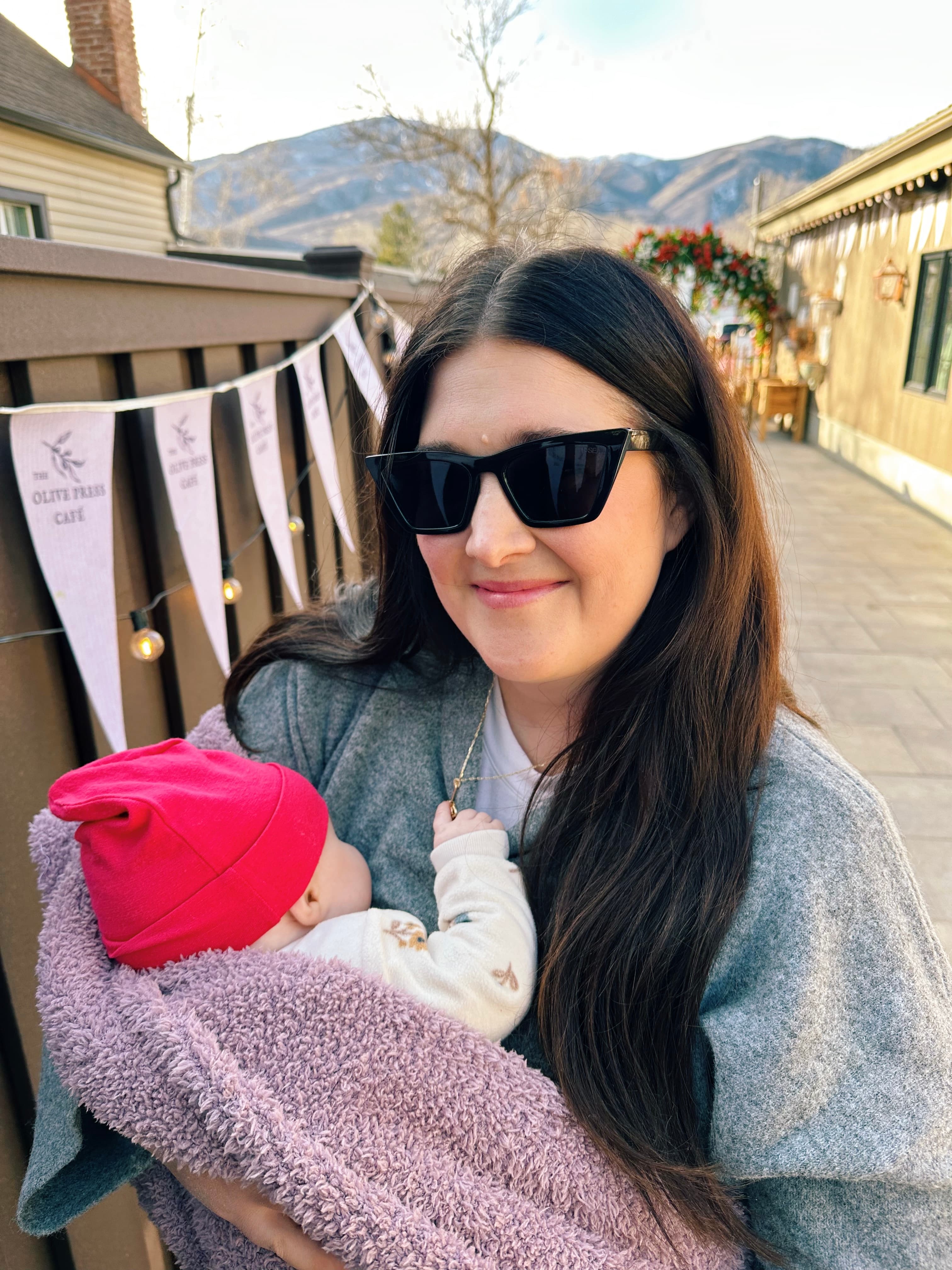 Darrian Wright holding a baby outdoors with mountains behind her